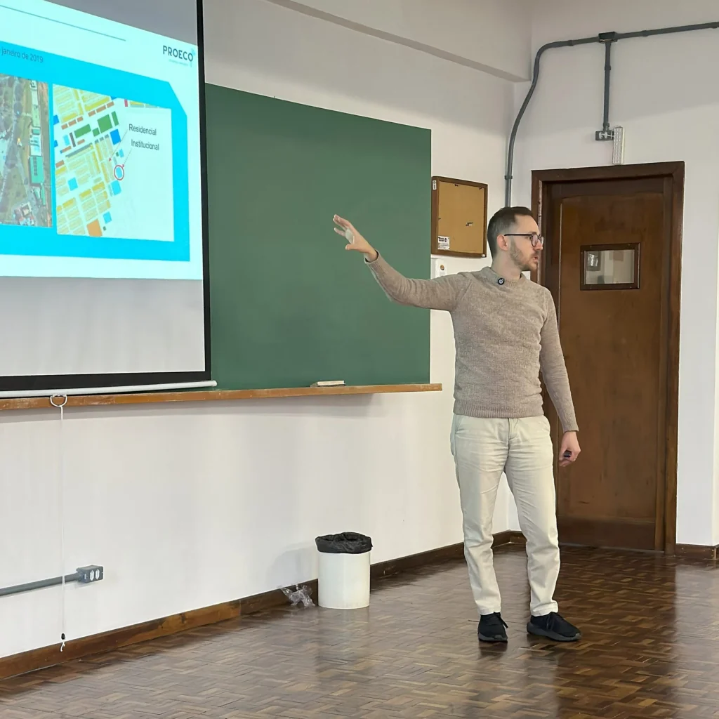 Imagem de um Engenheiro apresentando projetos acústicos em sala de aula, com mapa das normas e fazendo uma consultoria acústica.